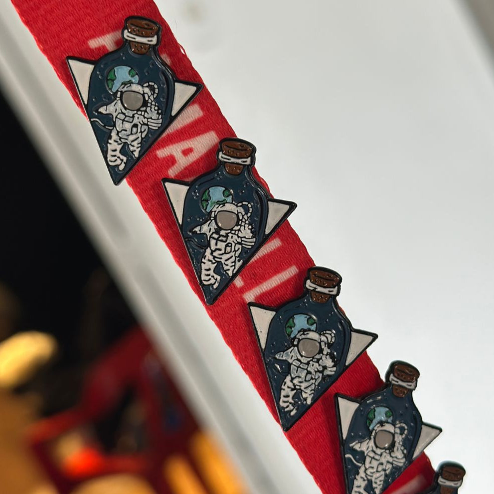 Pin astronauta triangular en planeta