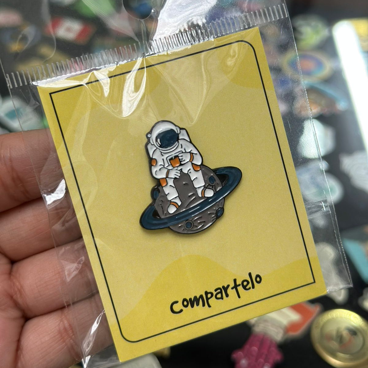Pin astronauta sentado en saturno
