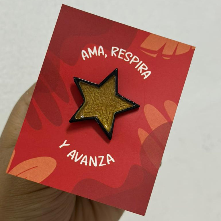 Pin estrella negra con dorado